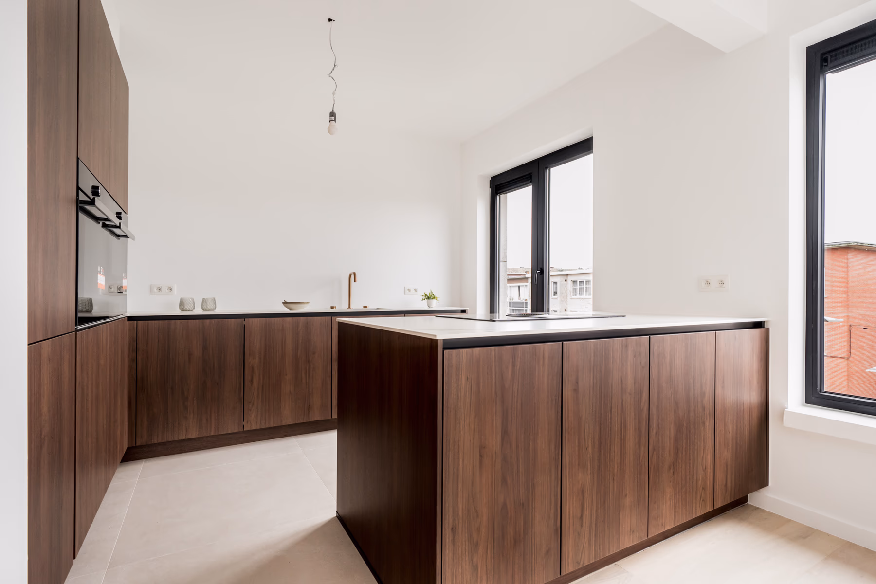 Moderne keuken met notenhouten kasten, wit werkblad en kookeiland, met grote zwarte ramen en lichte tegelvloer
